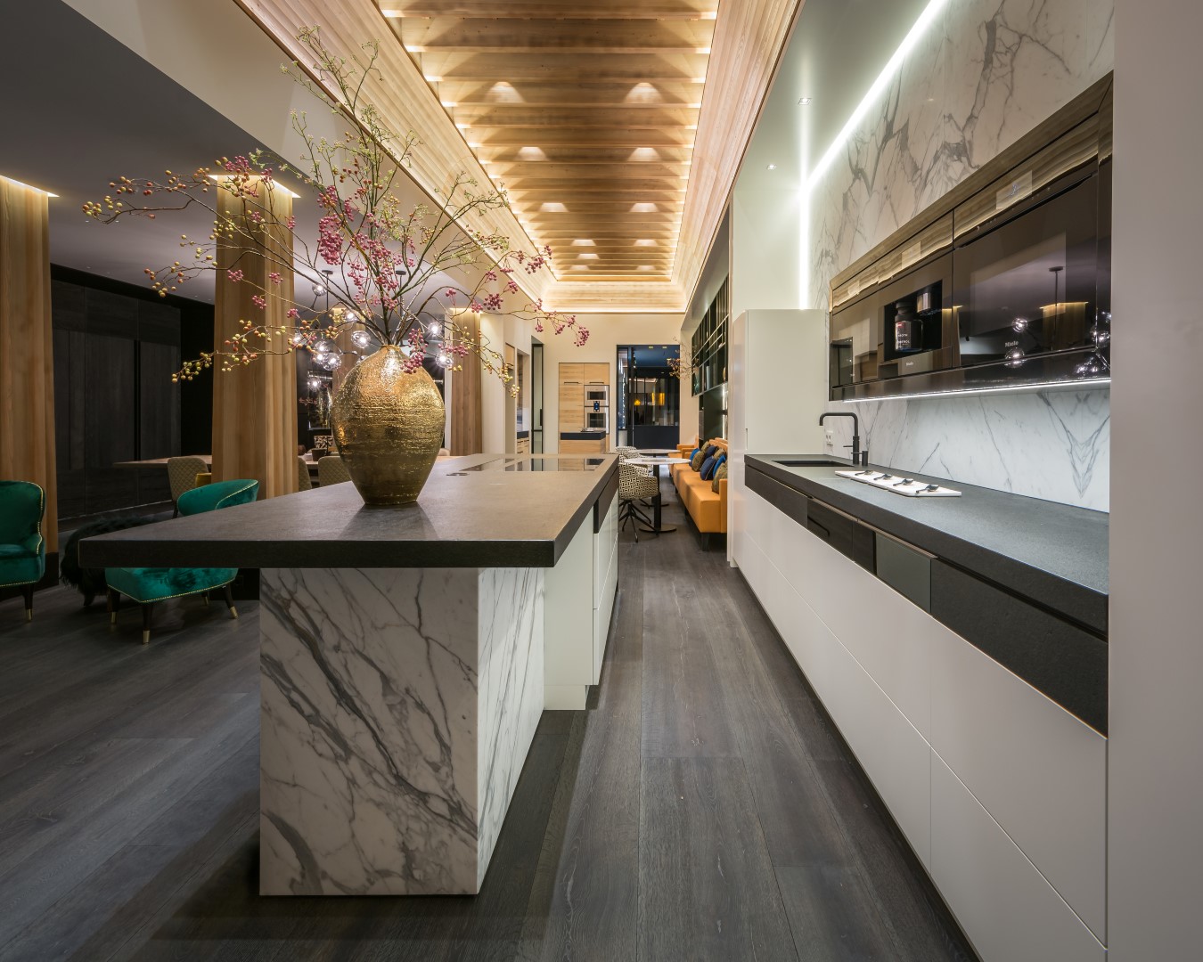 Bewerkt plafon met verlichting boven op maat gemaakte luxe keuken van natuursteen en graniet.