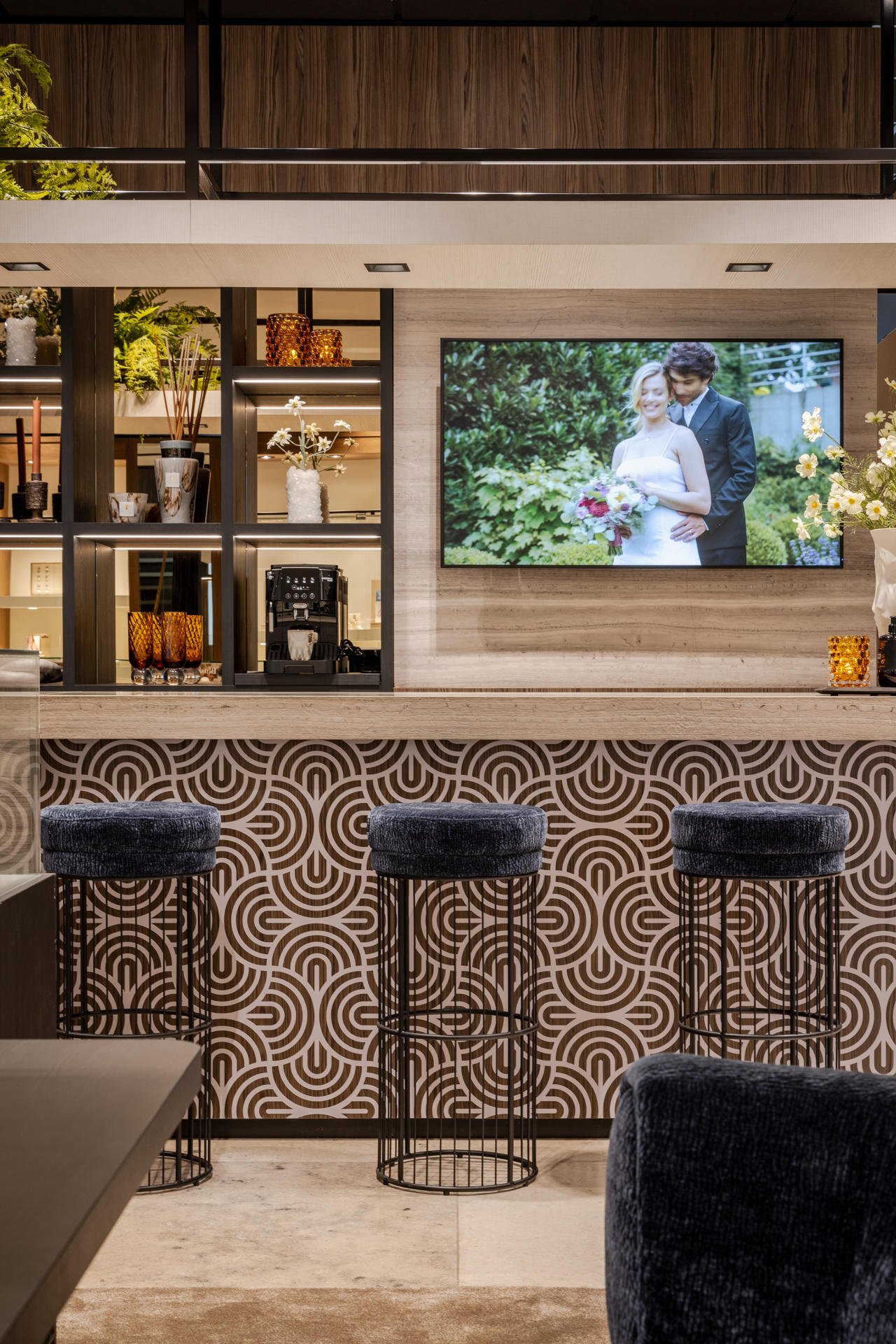 Comptoir habillé de matériau luxueux avec une vitrine assortie après la rénovation de la boutique De Bruyloft à Deurne.