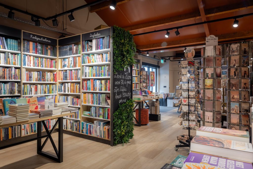 Warme winkelinrichting met grote presentatietafels voor boeken in De Boekenmolen in Meliskerke.